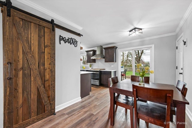 219 E Streamwood Blvd, Streamwood, IL 60107 - dining area featuring light wood-style floors, a barn door, baseboards, and crown molding