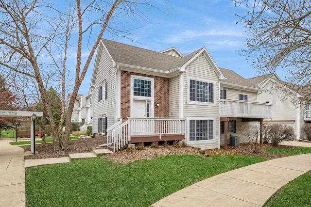 43 S Treehouse Ln, Round Lake, IL 60073 - view of front of property with brick siding, a wooden deck, central AC, and a front lawn