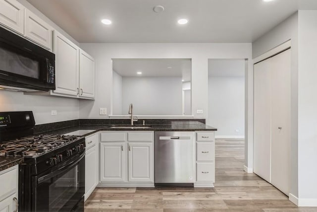 43 S Treehouse Ln, Round Lake, IL 60073 - kitchen with dark stone counters, black appliances, a sink, and light wood-style floors