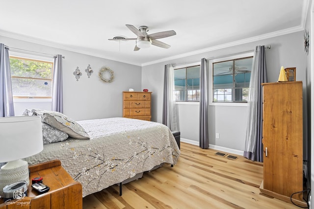 bedroom featuring visible vents, crown molding, baseboards, and light wood-style floors