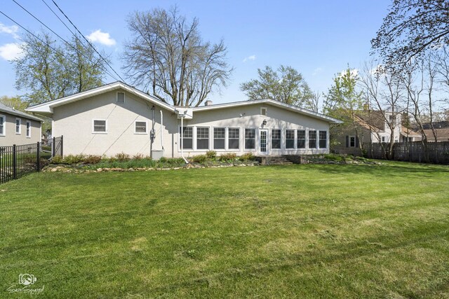 rear view of property featuring fence private yard, stucco siding, and a yard