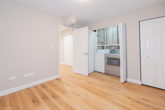 unfurnished bedroom featuring light wood-style floors, baseboards, and washing machine and dryer