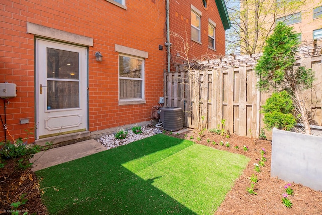 view of yard with fence and central AC unit