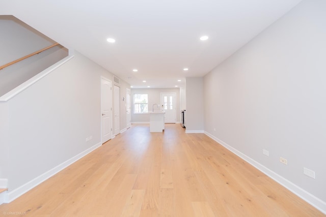 unfurnished living room with light wood-type flooring, recessed lighting, and baseboards