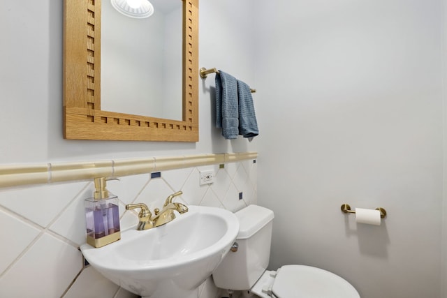 bathroom featuring toilet, tasteful backsplash, and a sink