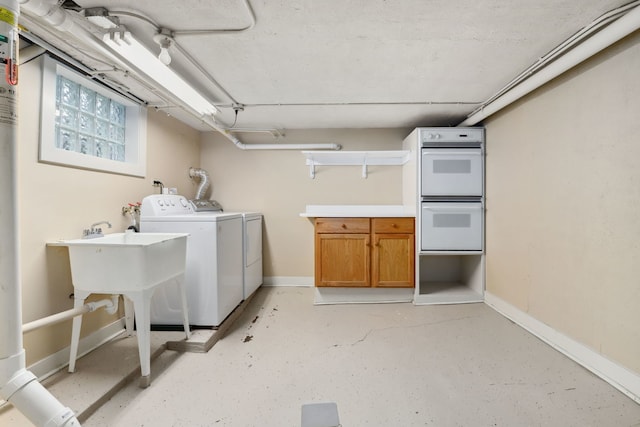 laundry room featuring cabinet space, baseboards, and separate washer and dryer