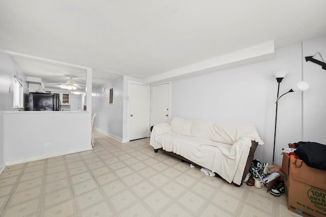 living room with light floors, baseboards, and ceiling fan