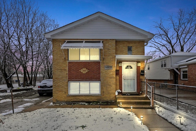 view of front of home featuring brick siding and fence