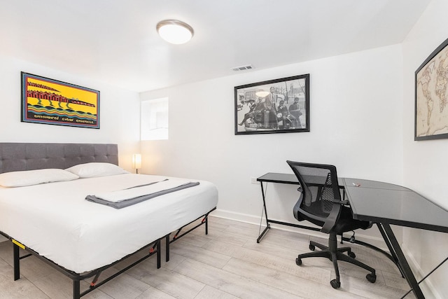 bedroom featuring visible vents, light wood-style flooring, and baseboards