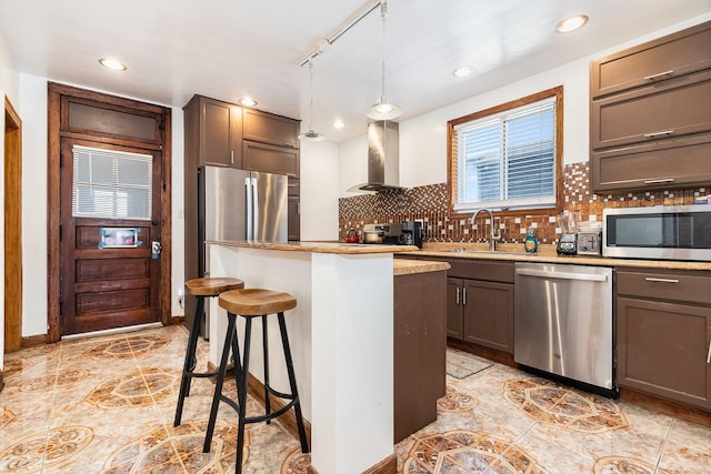 kitchen with tasteful backsplash, a sink, stainless steel appliances, a center island, and exhaust hood