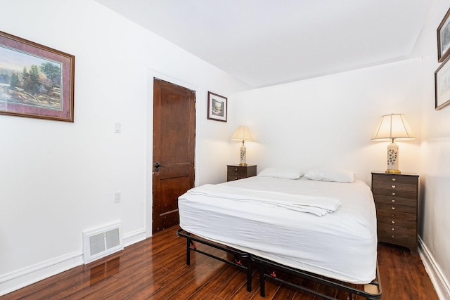 bedroom with wood finished floors, visible vents, and baseboards