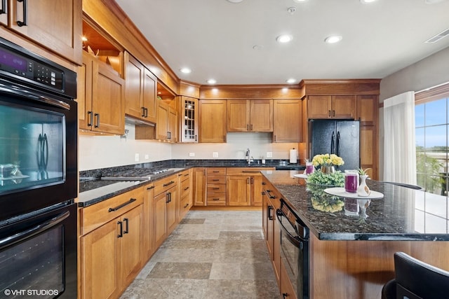 14 S Prospect St Unit 508, Roselle, IL 60172 - kitchen featuring black appliances, recessed lighting, dark stone counters, glass insert cabinets, and a kitchen island