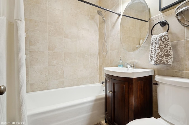 bathroom with tile walls, shower / bath combo, vanity, and toilet