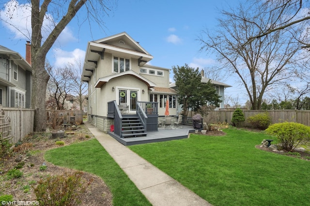 back of house with a lawn, a fenced backyard, stucco siding, and a deck