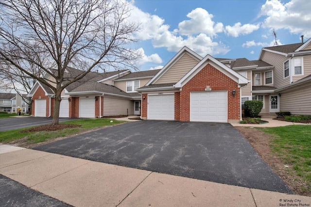 view of front of home with brick siding, driveway, and a garage