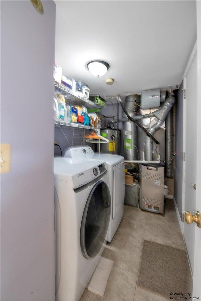 washroom with gas water heater, laundry area, light tile patterned floors, heating unit, and washer and clothes dryer