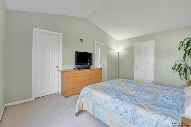 bedroom with baseboards, lofted ceiling, and light carpet