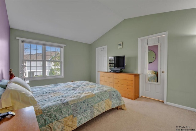 bedroom with baseboards, light carpet, and lofted ceiling
