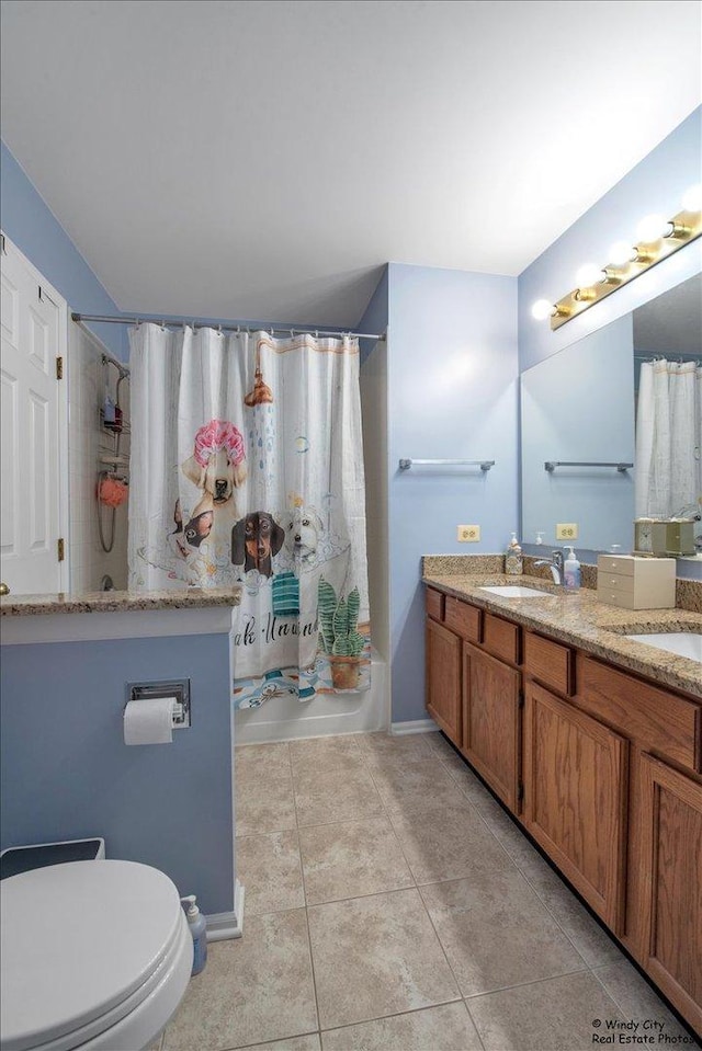 bathroom featuring double vanity, shower / bath combination with curtain, a sink, tile patterned floors, and toilet