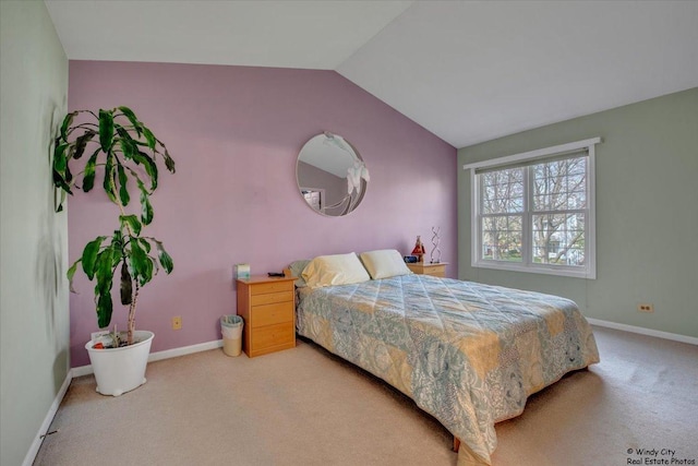 bedroom with baseboards, vaulted ceiling, and light carpet