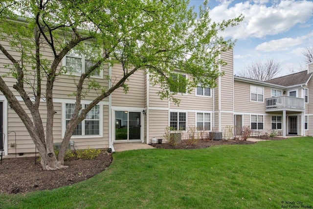 rear view of property featuring a lawn, central AC unit, and a chimney
