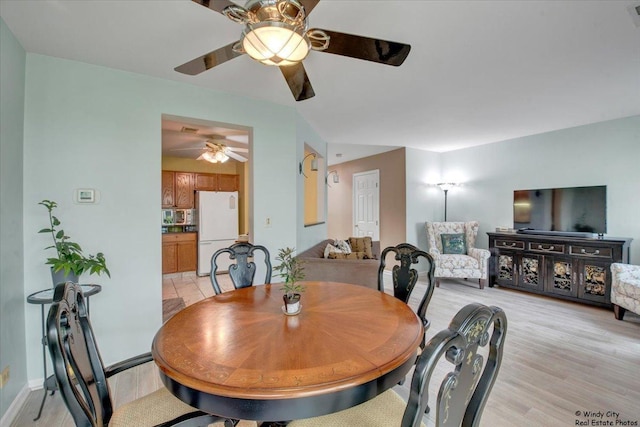 dining area with baseboards, a ceiling fan, light wood-type flooring, and visible vents