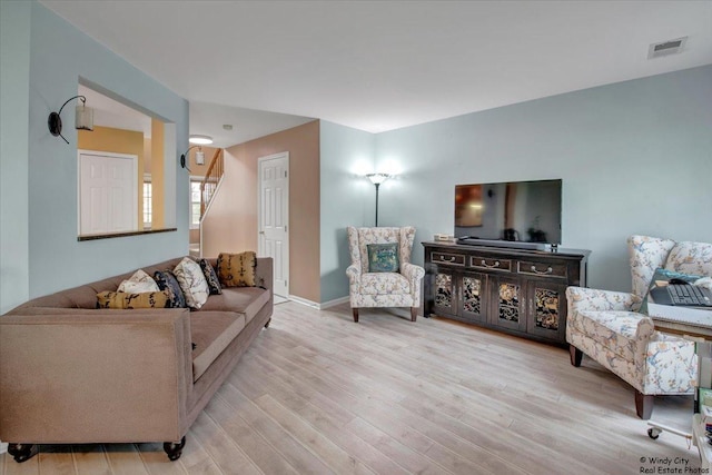 living area with visible vents and wood finished floors