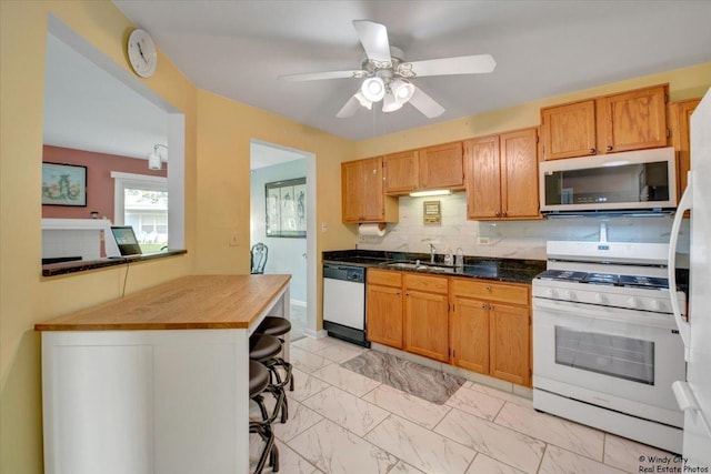 kitchen with a sink, white appliances, marble finish floor, a ceiling fan, and tasteful backsplash