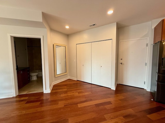 651 N Milwaukee Ave Unit 403, Chicago, IL 60642 - unfurnished bedroom featuring visible vents, a closet, recessed lighting, wood finished floors, and refrigerator with ice dispenser