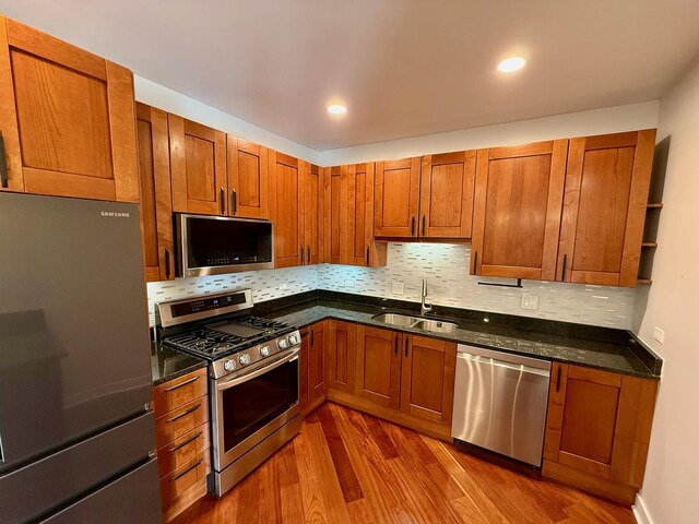 651 N Milwaukee Ave Unit 403, Chicago, IL 60642 - kitchen with dark wood-style flooring, stainless steel appliances, backsplash, and a sink