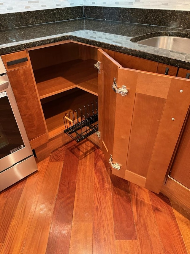 651 N Milwaukee Ave Unit 403, Chicago, IL 60642 - interior details featuring dark stone countertops, backsplash, and wood finished floors