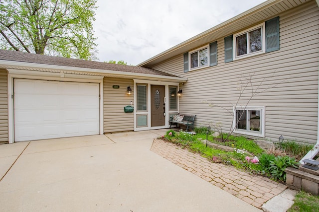 tri-level home featuring an attached garage and concrete driveway