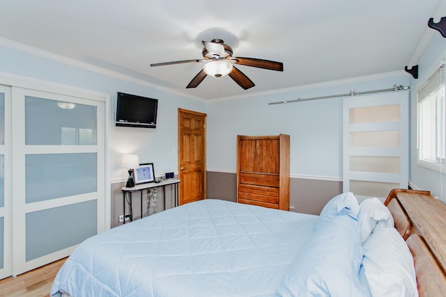 bedroom with ornamental molding, a ceiling fan, and light wood-type flooring