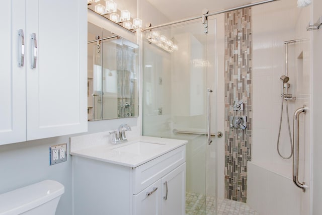 bathroom with vanity, toilet, and a stall shower