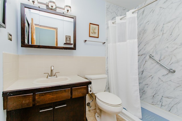 full bath with vanity, a shower stall, toilet, and tile walls