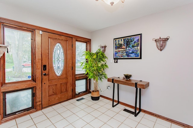 entrance foyer with baseboards, light tile patterned floors, and visible vents