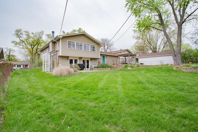 rear view of house with a lawn, fence, and french doors