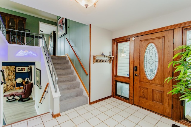 foyer featuring baseboards and stairs