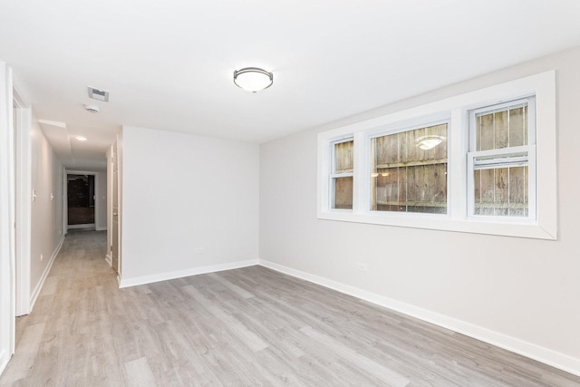 unfurnished room featuring baseboards, a healthy amount of sunlight, and light wood finished floors