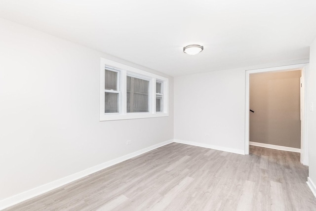 unfurnished room with light wood-style flooring and baseboards