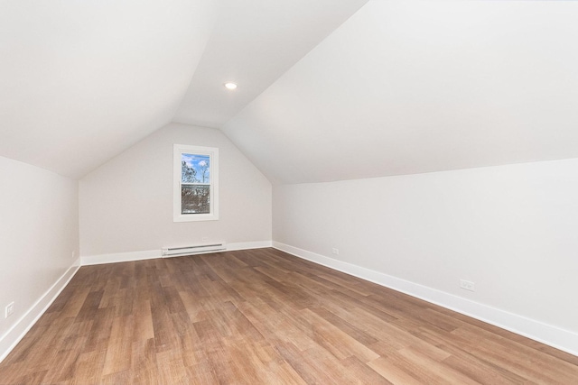 bonus room with vaulted ceiling, a baseboard radiator, baseboards, and light wood-style floors