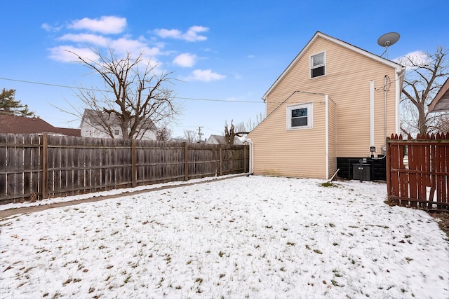 snow covered property with a fenced backyard