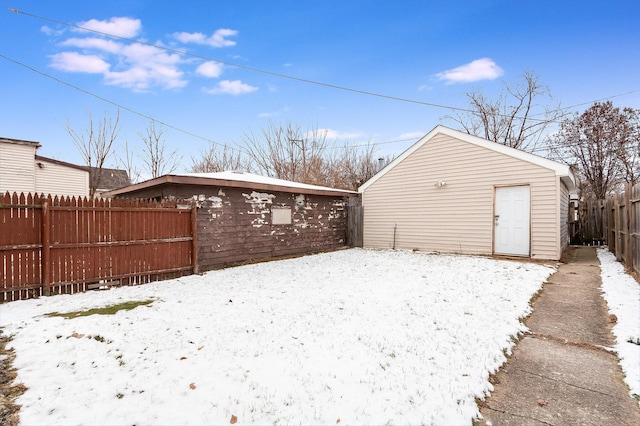 yard covered in snow with a fenced backyard and an outbuilding