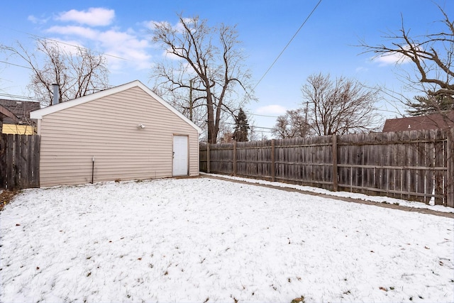 yard layered in snow with a fenced backyard and an outbuilding