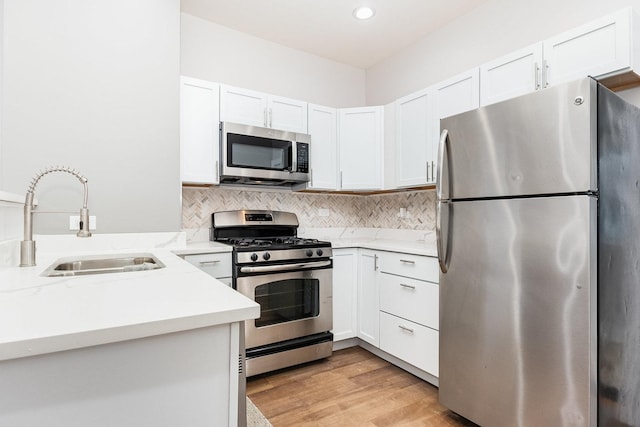 kitchen with white cabinetry, stainless steel appliances, and a sink