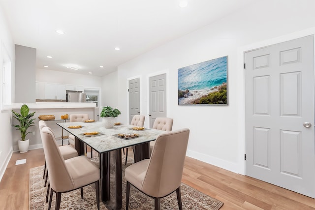 dining space featuring baseboards, light wood-style floors, and recessed lighting