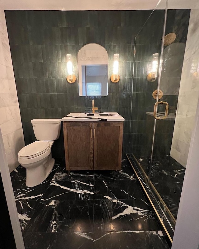 full bathroom with vanity, a shower stall, toilet, and marble finish floor