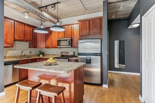 1228 W Monroe St Unit 301, Chicago, IL 60607 - kitchen with appliances with stainless steel finishes, light wood-style flooring, tasteful backsplash, and a center island