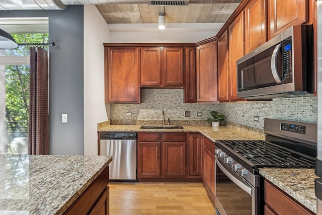 1228 W Monroe St Unit 301, Chicago, IL 60607 - kitchen with appliances with stainless steel finishes, a sink, light wood finished floors, and decorative backsplash