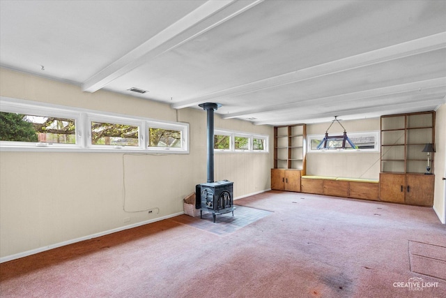 339 3rd St, Downers Grove, IL 60515 - unfurnished living room with carpet flooring, beam ceiling, visible vents, baseboards, and a wood stove